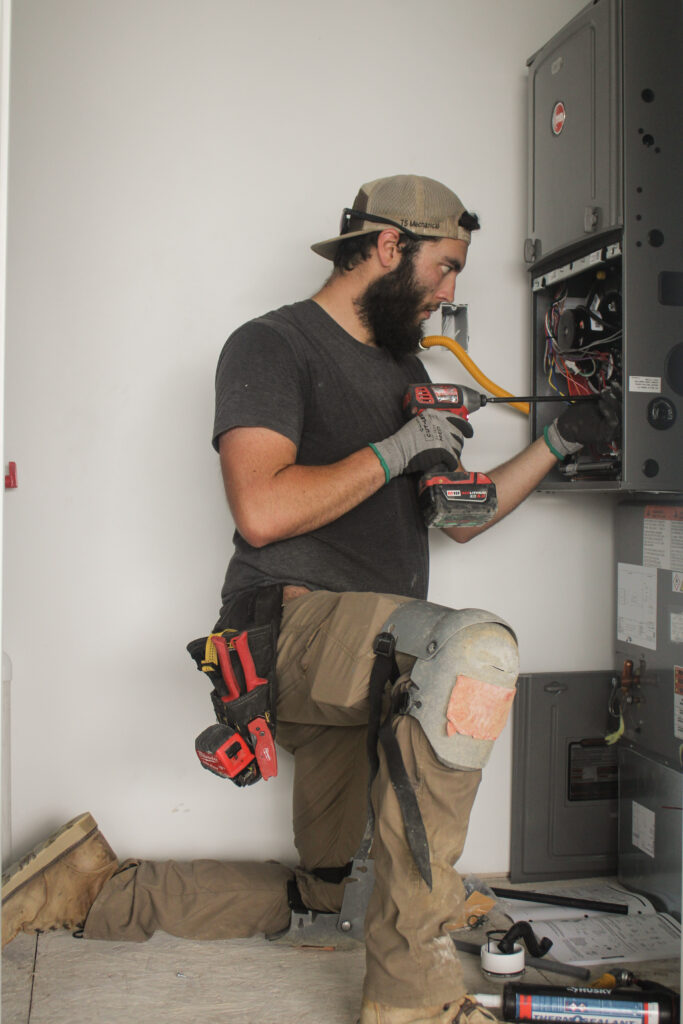 HVAC technician working on furnace